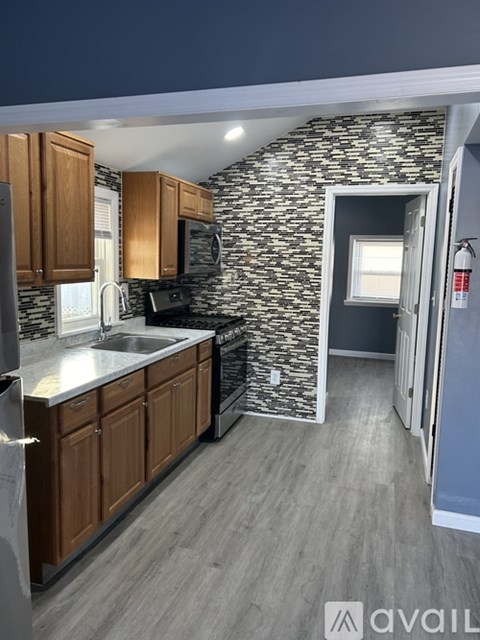A kitchen with wooden cabinets and a stone wall.