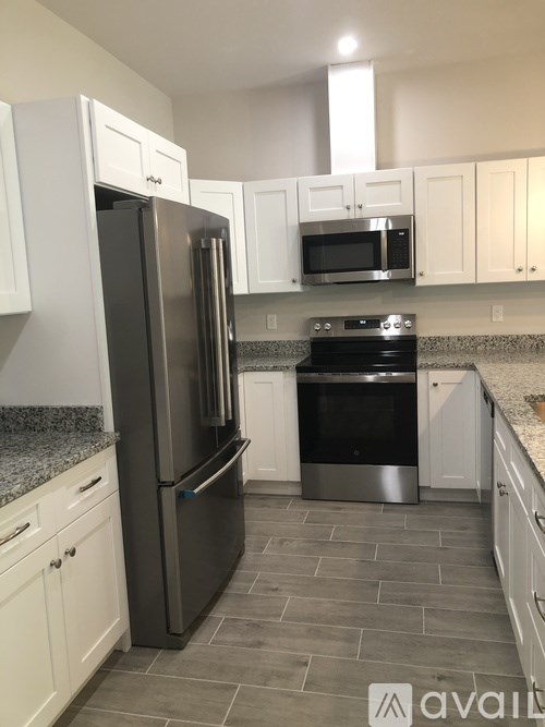 A kitchen with a black refrigerator and stove.