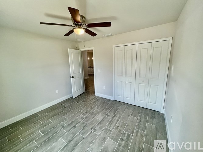 A room with a ceiling fan and a doorway leading to another room.
