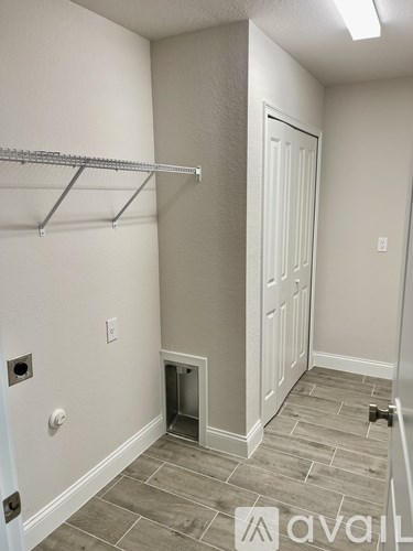 A room with a white door, a white wall, and a white shelf.