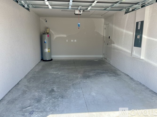 A spacious garage with a concrete floor and a wall-mounted fire extinguisher.