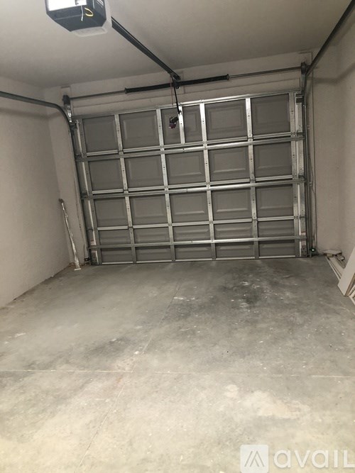 A large garage door is open in a spacious garage.