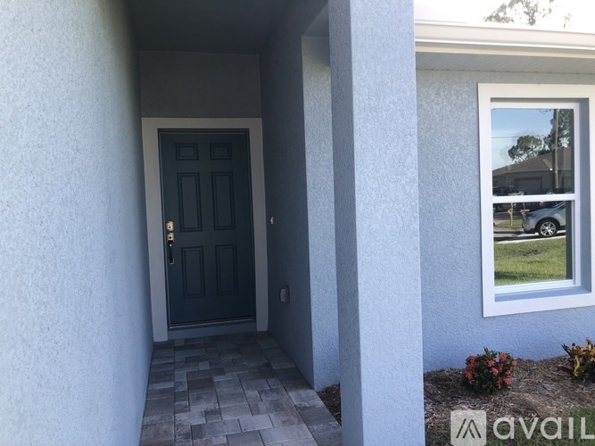A black door is on the left side of a white wall.