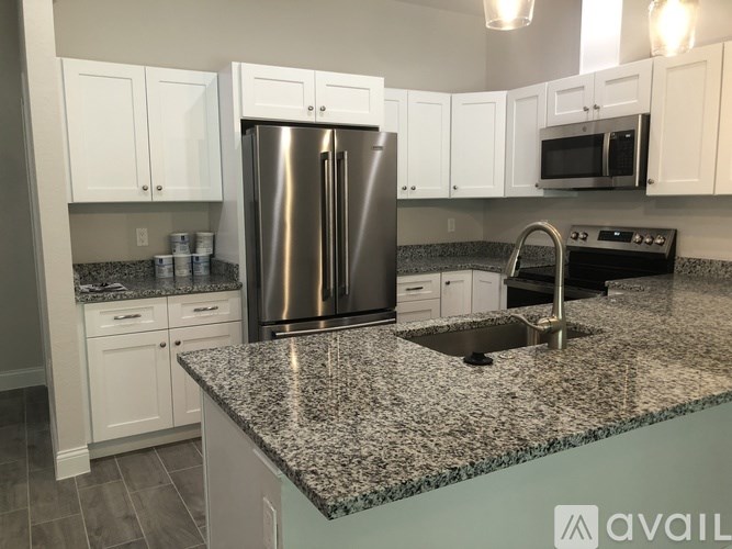 A kitchen with granite countertops and stainless steel appliances.
