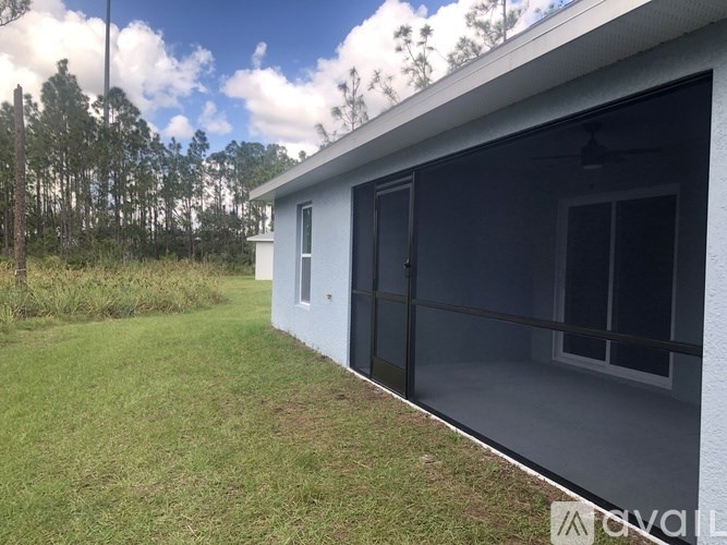 A house with a grey exterior and a glass door is shown.