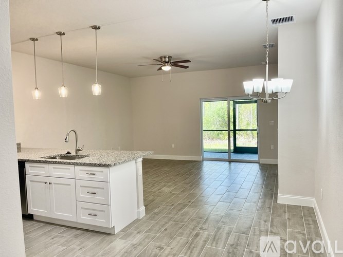 A kitchen with a granite countertop and white cabinets.