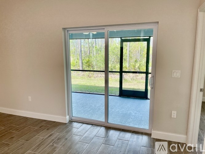 A room with a sliding glass door leading to a backyard.