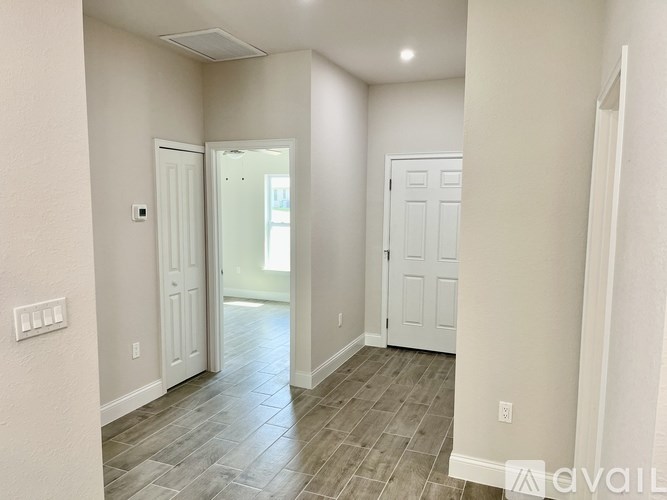 A hallway with two doors and a tiled floor.