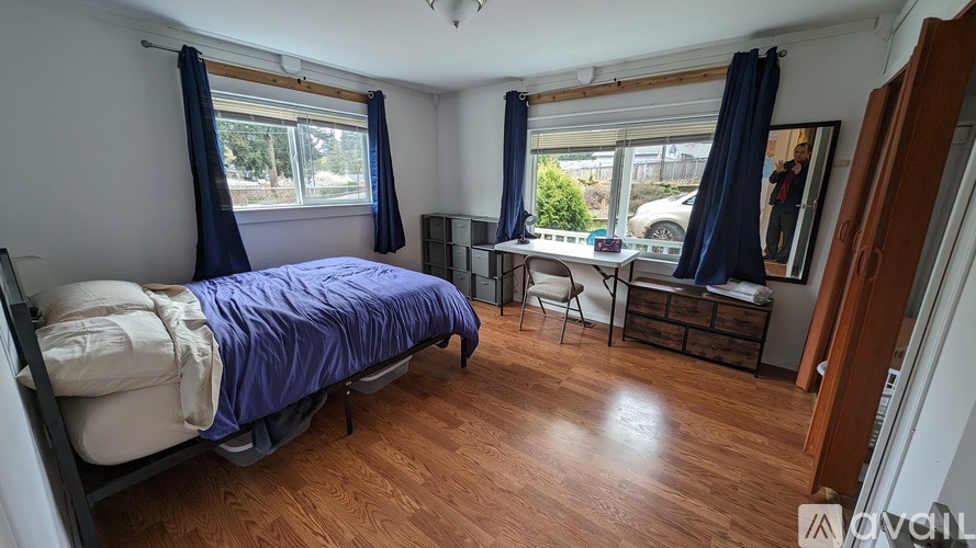 A bedroom with a bed, desk, and chair.