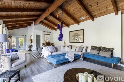 A living room with a blue couch and a wooden coffee table.