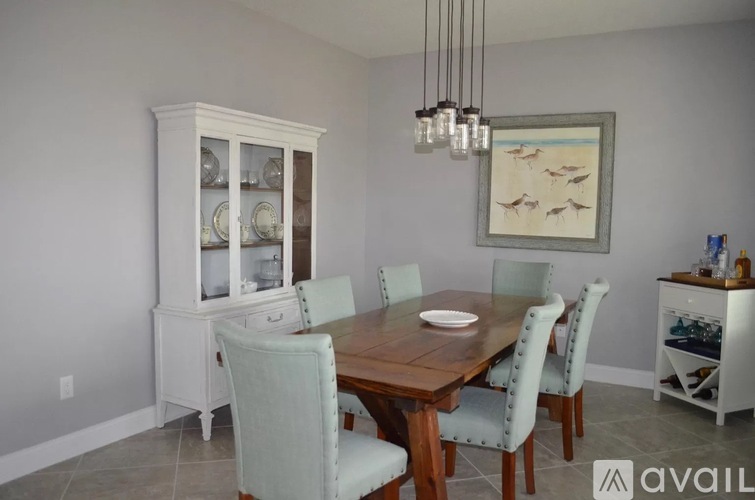 A dining room with a wooden table and chairs.