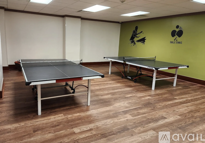 A spacious room with tables and chairs and a television on the wall.