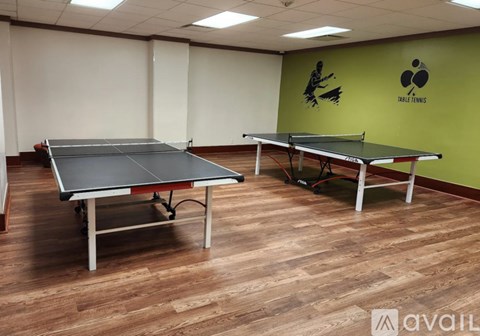 A spacious room with tables and chairs and a television on the wall.