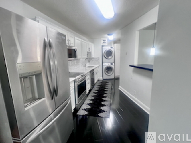 A kitchen with a black countertop and a microwave above it.