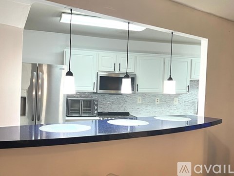 A kitchen with a black countertop and a microwave above it.