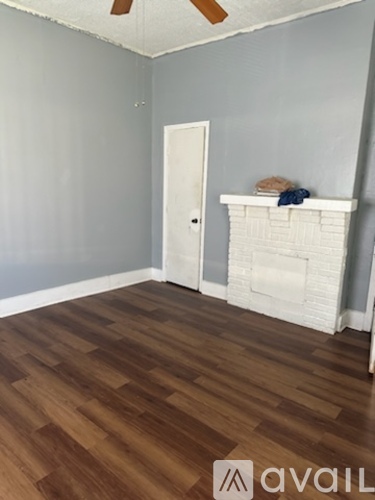 A room with a white door and a fireplace.