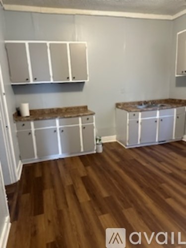 A kitchen with white cabinets and a brown countertop.