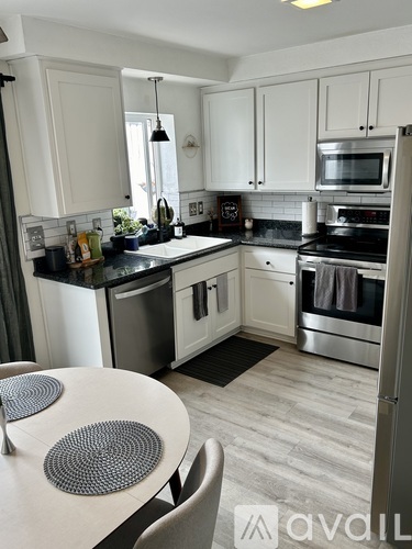 A kitchen with a table and chairs.