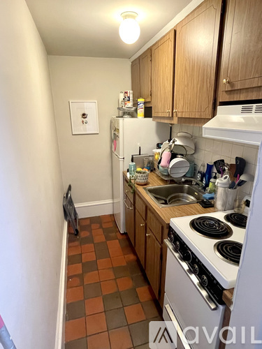 A kitchen with a white stove and a refrigerator.