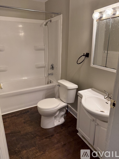 A white toilet sits in a bathroom next to a sink.