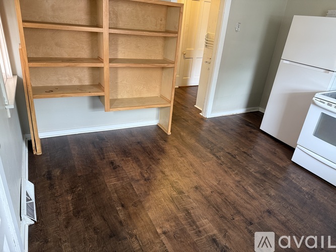 A kitchen with a white refrigerator and wooden floors.