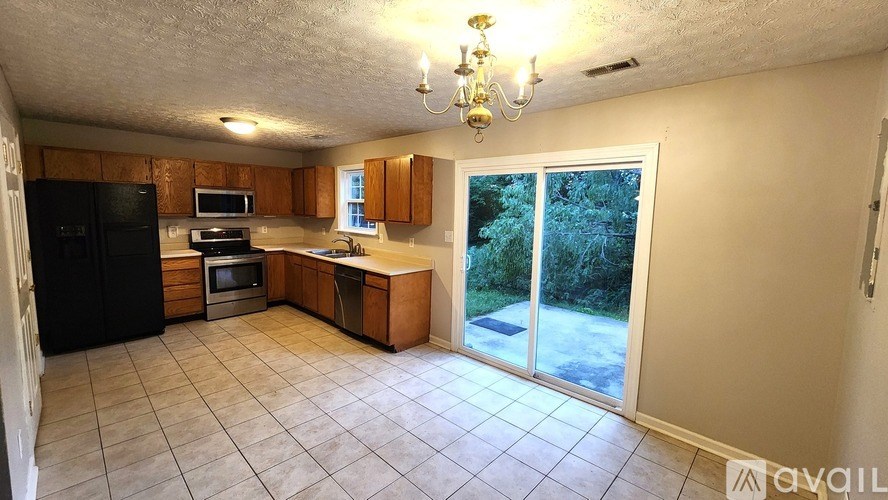 A kitchen with black appliances and wooden cabinets.