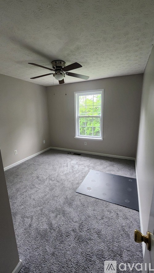 A room with a ceiling fan and a window.