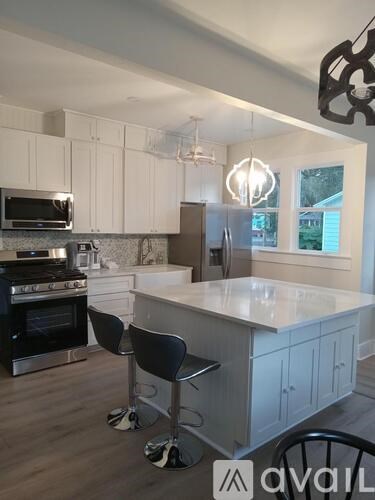 A kitchen with white cabinets and a black stove top oven.