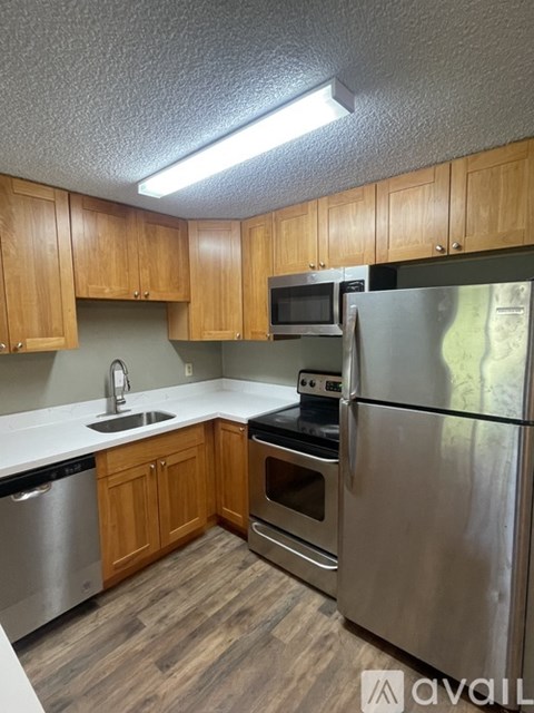 A kitchen with wooden cabinets and stainless steel appliances.