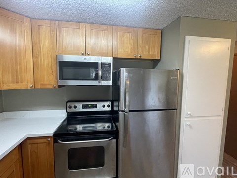 A kitchen with a stove, oven, microwave, and refrigerator.