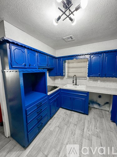A kitchen with blue cabinets and a white sink.