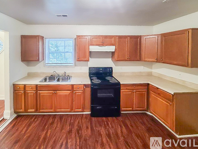 A kitchen with wooden cabinets and a black dishwasher.