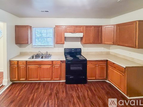 A kitchen with wooden cabinets and a black dishwasher.