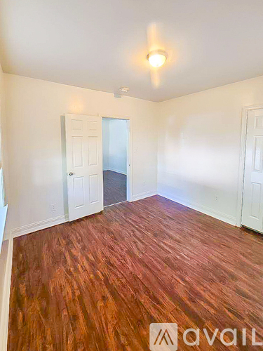 A room with wooden flooring and white walls.