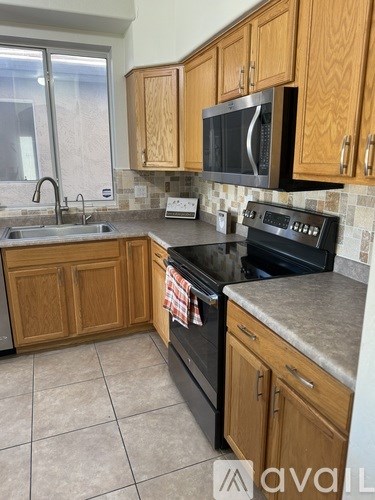 A kitchen with wooden cabinets and a black oven.