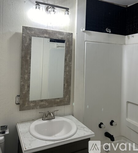 A bathroom with a sink, mirror and toilet.