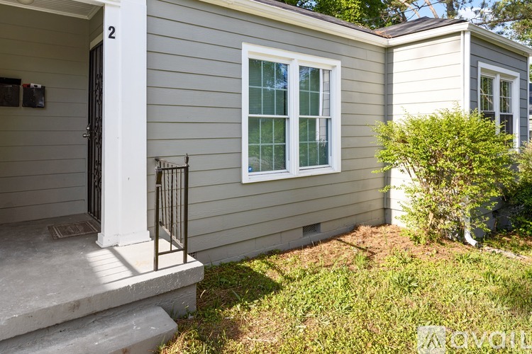 A house with a grey siding and a white door is shown.