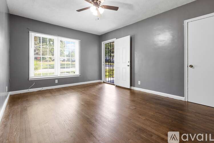 A room with a ceiling fan and wooden flooring.