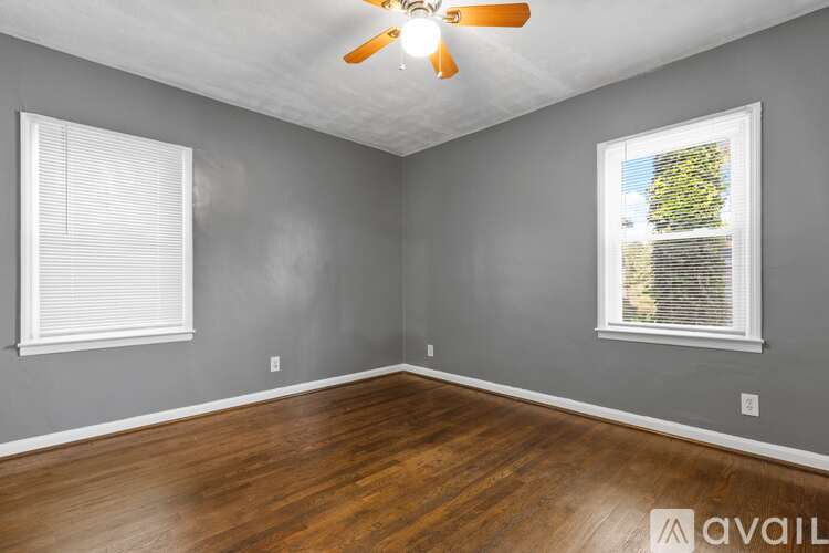A room with a ceiling fan and a window with blinds.
