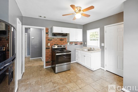 A kitchen with a brick wall and a stove top oven.