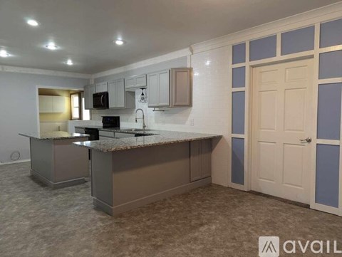 A kitchen with a counter and cabinets is available for rent.