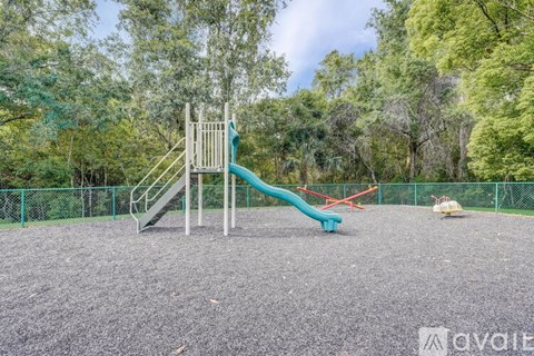 A playground with a green slide and a red slide.