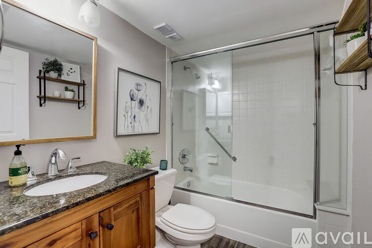 A bathroom with a toilet, sink, and shower.