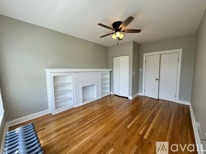 A room with a fireplace and a ceiling fan.