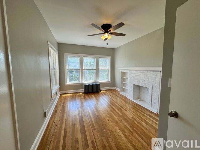 A room with wooden floors and a ceiling fan.