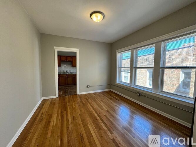 A room with wooden floors and a large window.