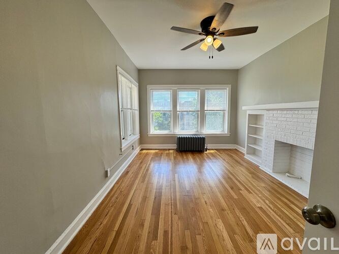 A room with wooden floors and a ceiling fan.