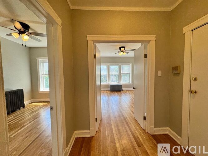 A hallway with wood floors and a ceiling fan.