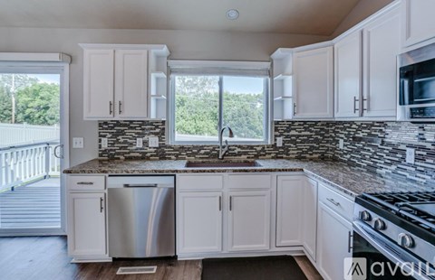 A kitchen with white cabinets and a black stove top.