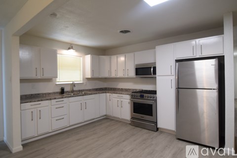 A kitchen with white cabinets and stainless steel appliances.